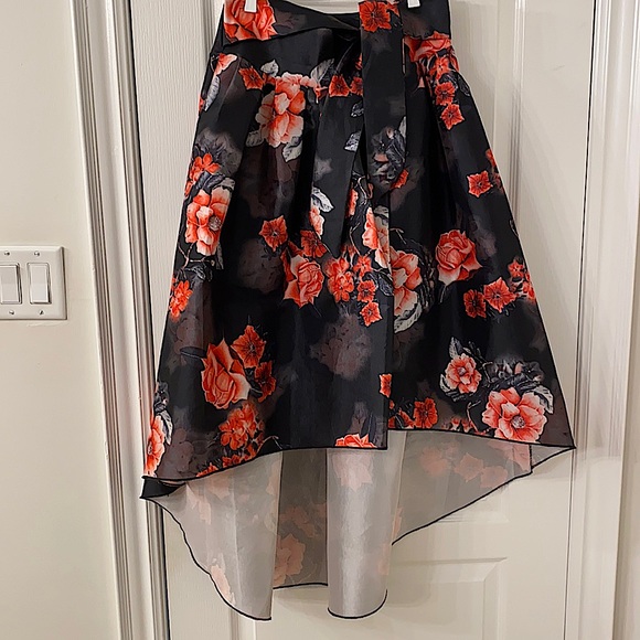 Black with floral skirt. Shorter front and comes longer in back - Picture 1 of 1